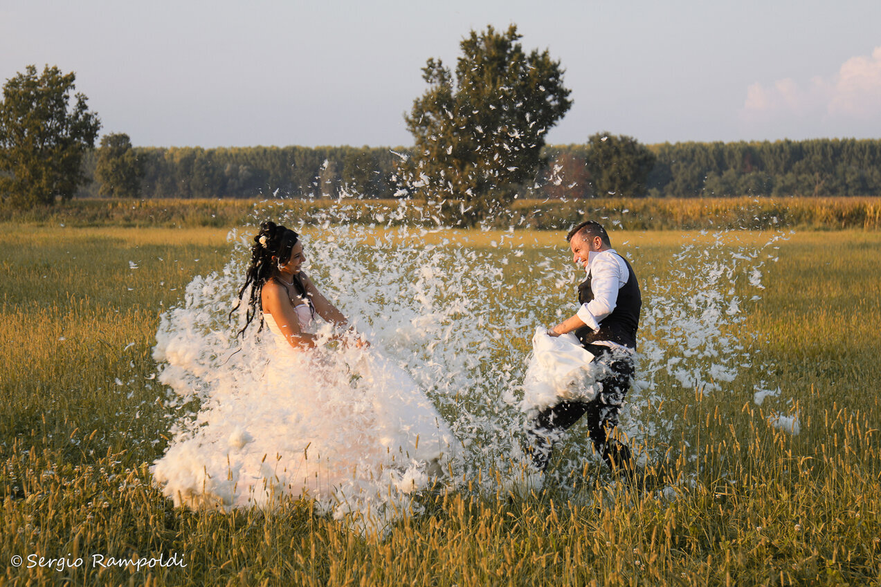 Wedding La battaglia dei cuscini Due sposi che giocano prendondosi a cuscinate dove volano tutte le piume al loro interno
